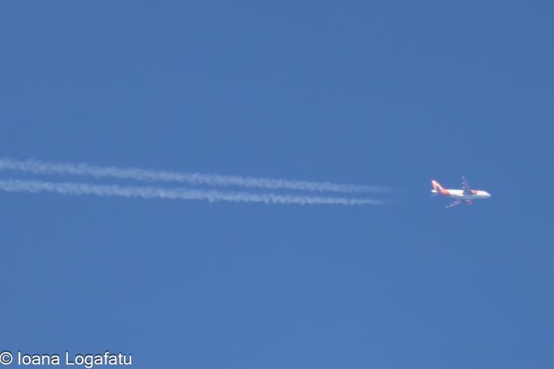 Bright airplane gliding through clear blue sky